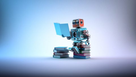 A robot sits on a pile of books and reads.