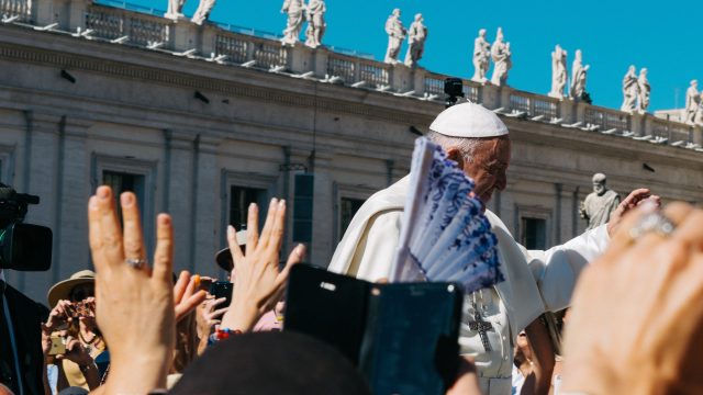 The Pope is greeted by Catholics.