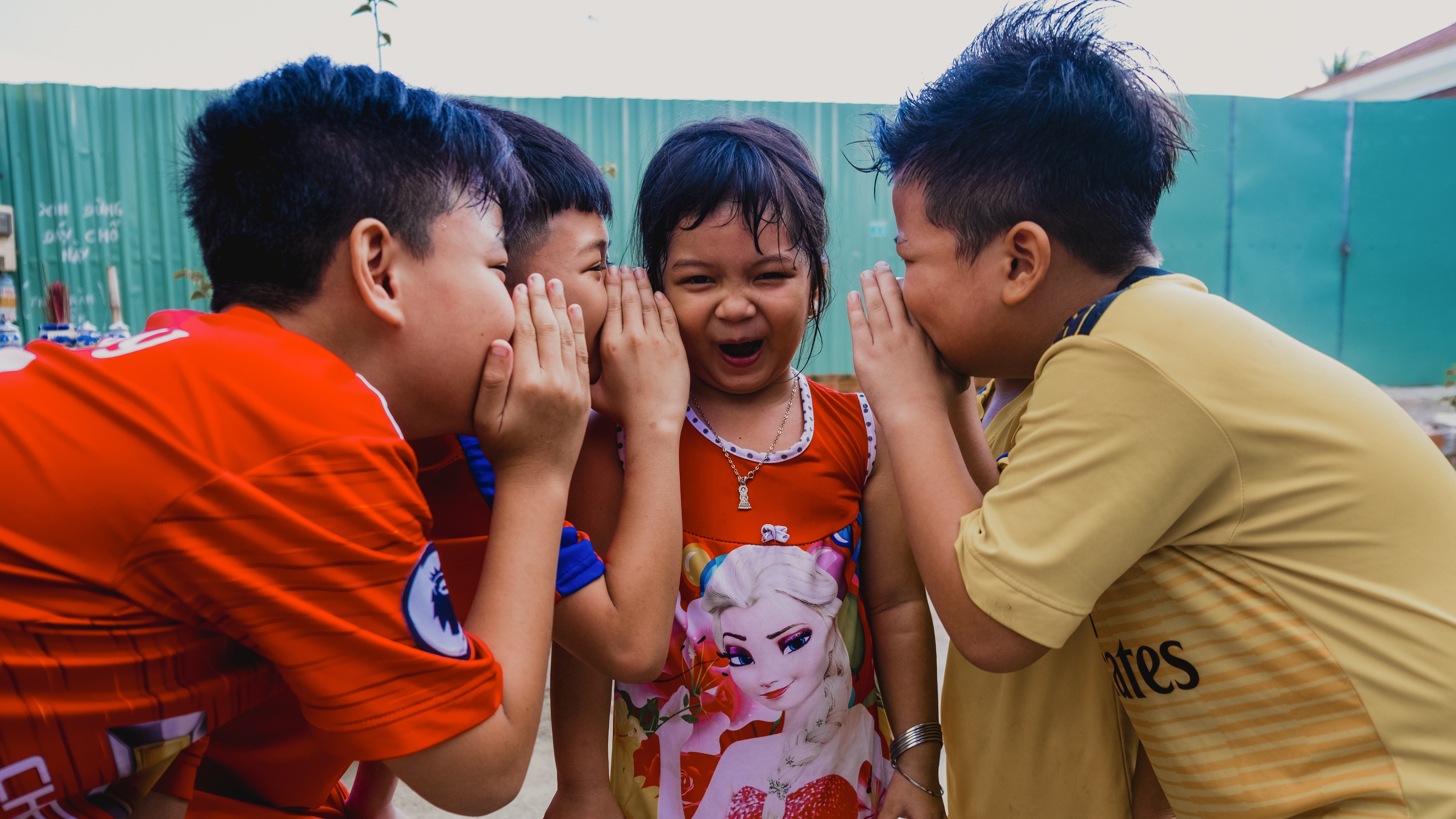 Four children gossiping illustrating that gossip is a social skill