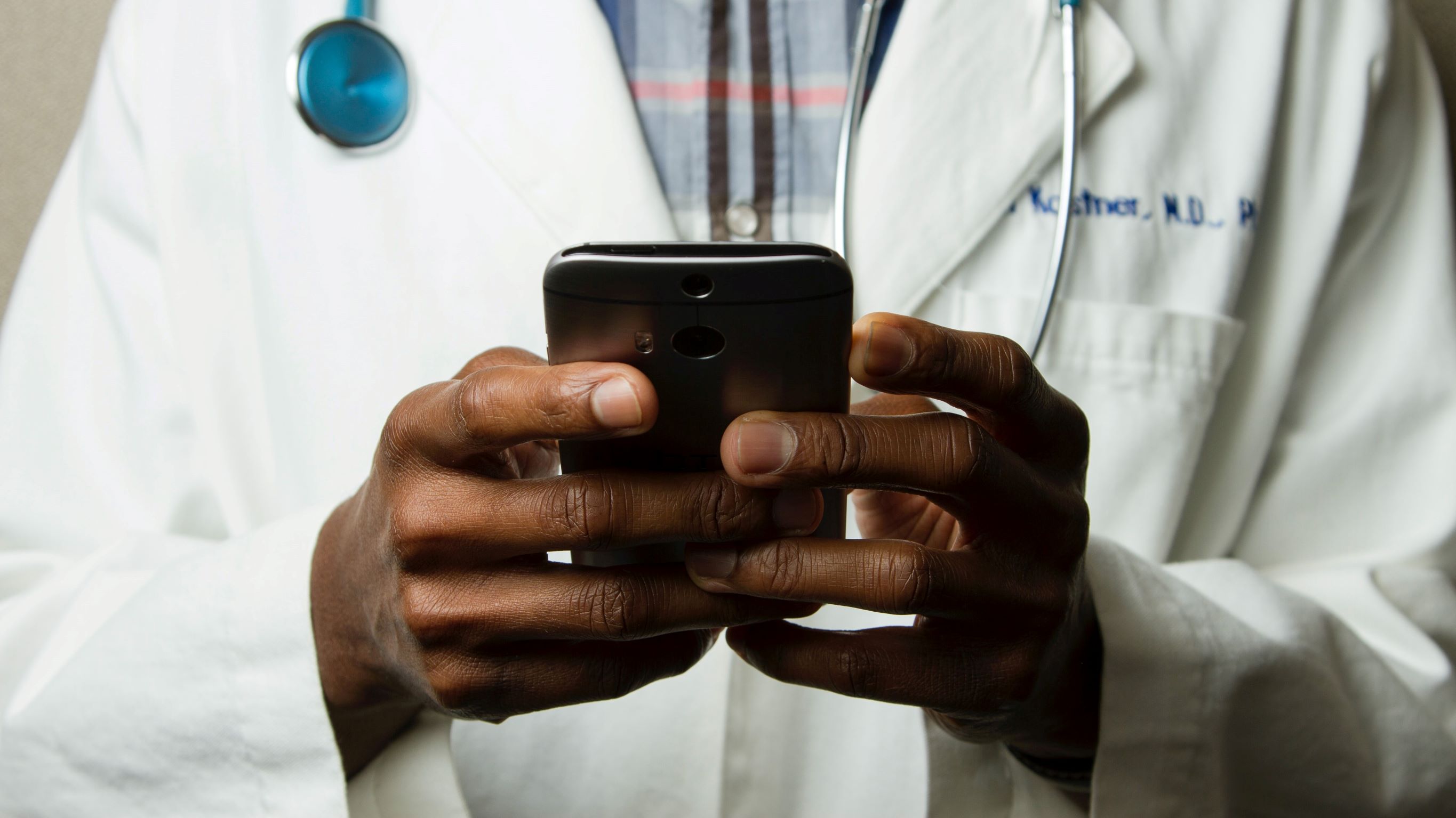 Closeup of a doctor's hands using a smartphone.