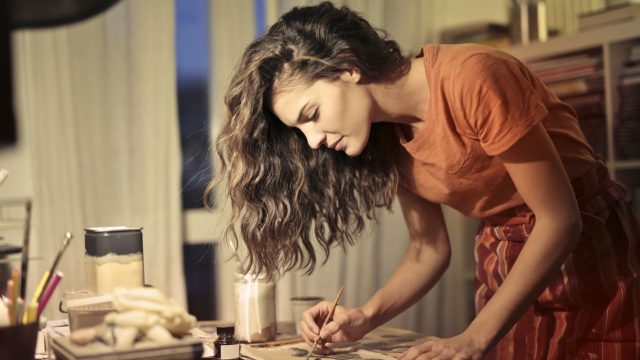 A woman paints as part of her creative habit.