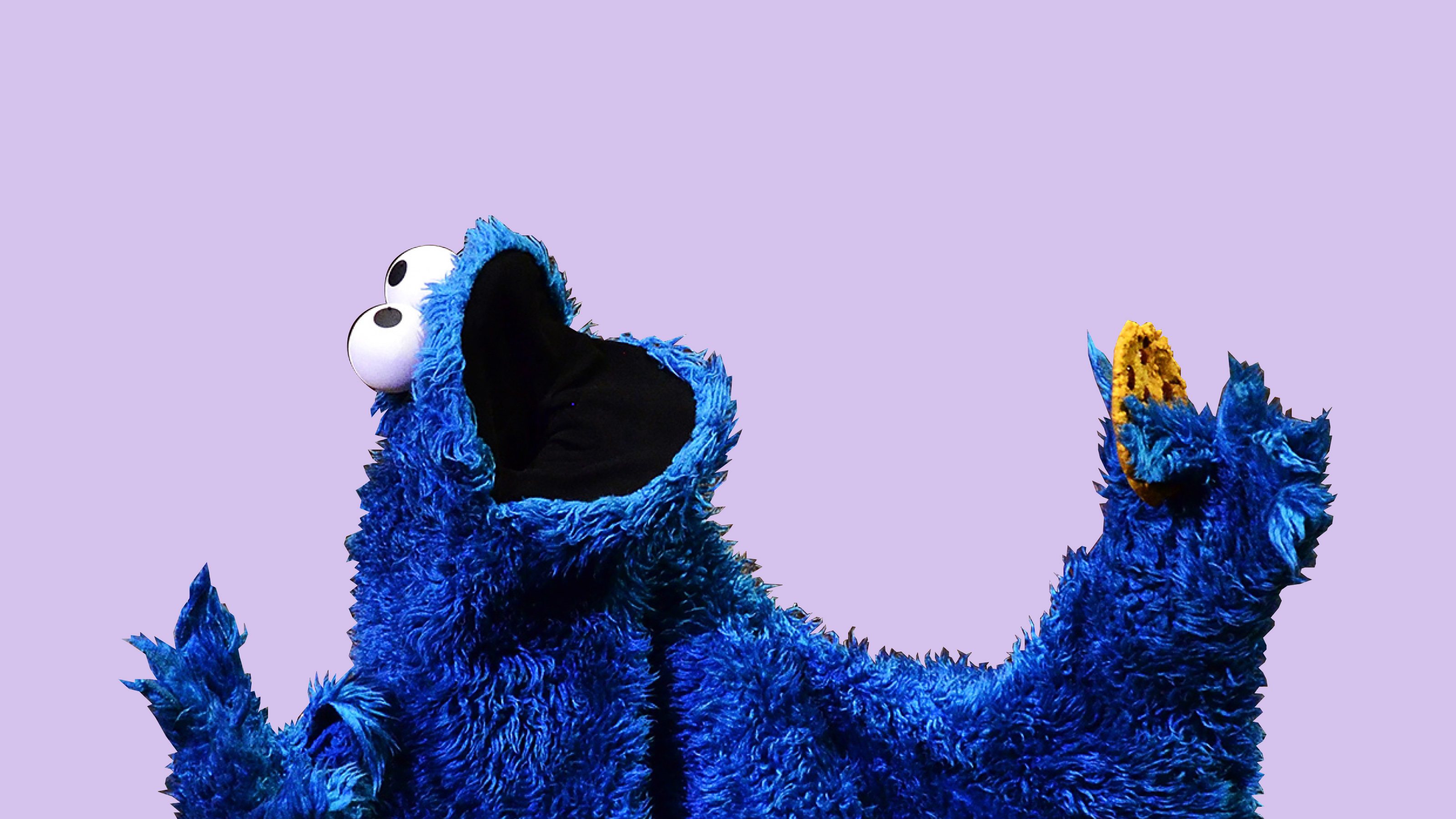 a close up of a cookie monster holding a banana.