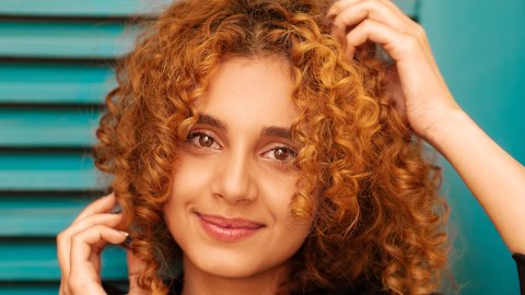 a close up of a person with curly hair.