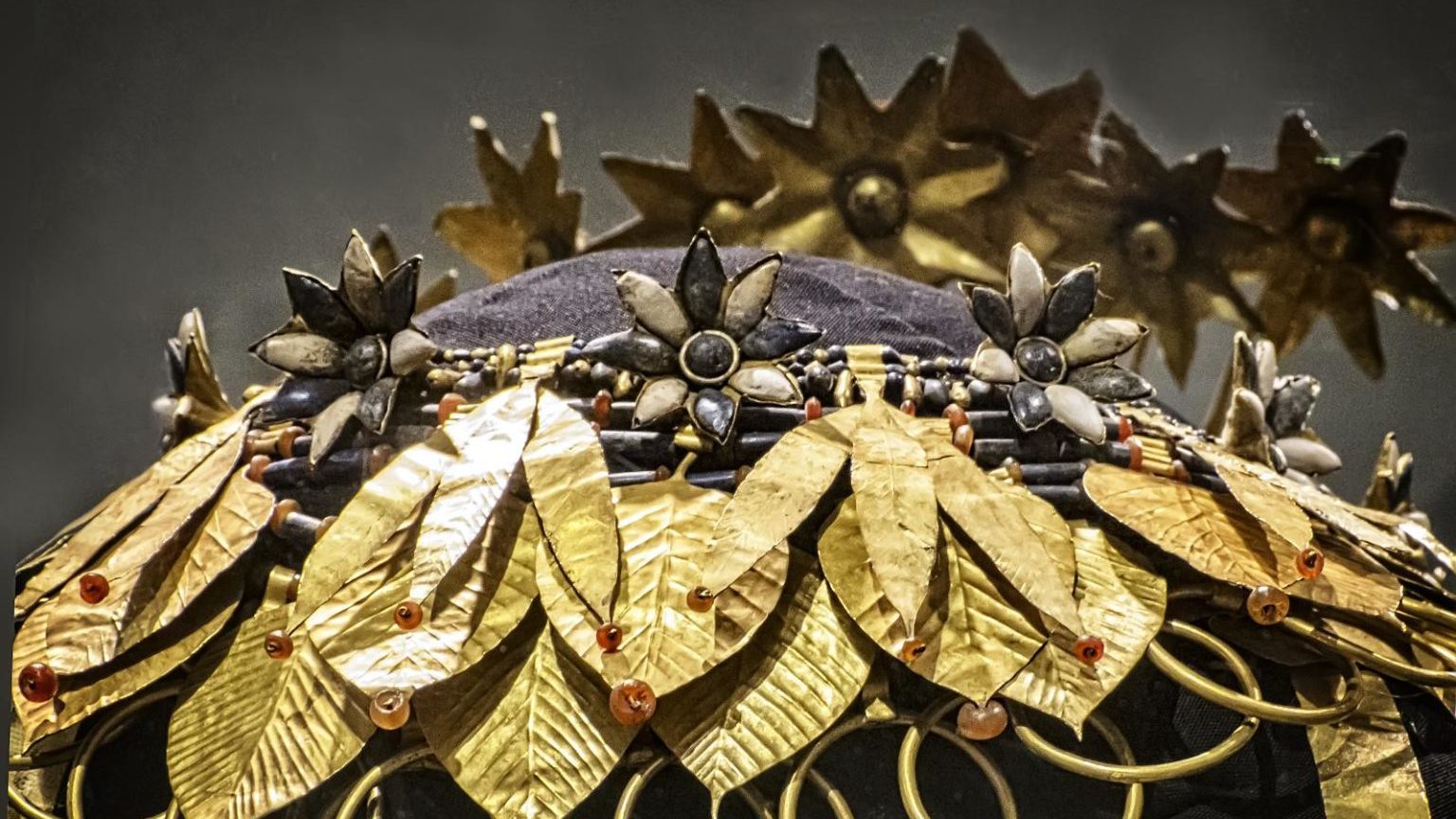 a close up of a hat with gold leaves on it.