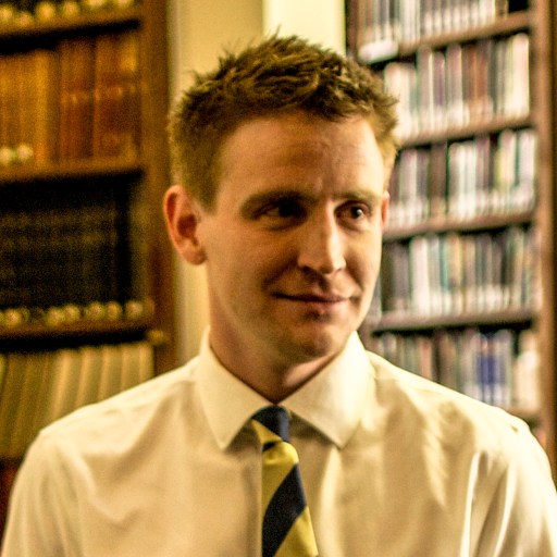 a man in a white shirt and yellow tie.