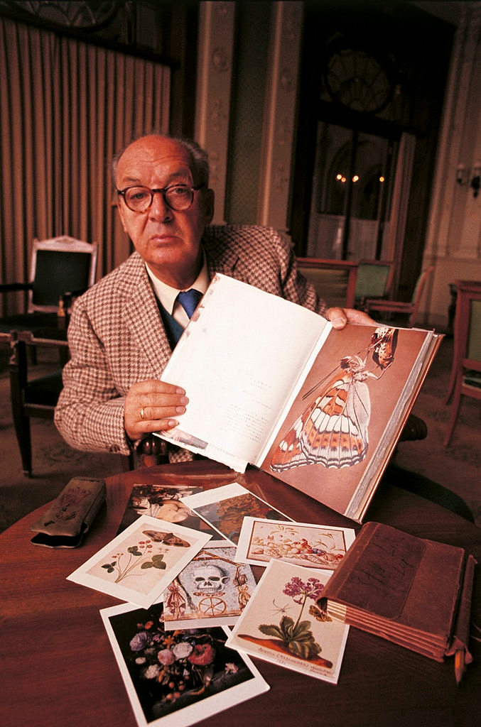 a man sitting at a table holding a book.