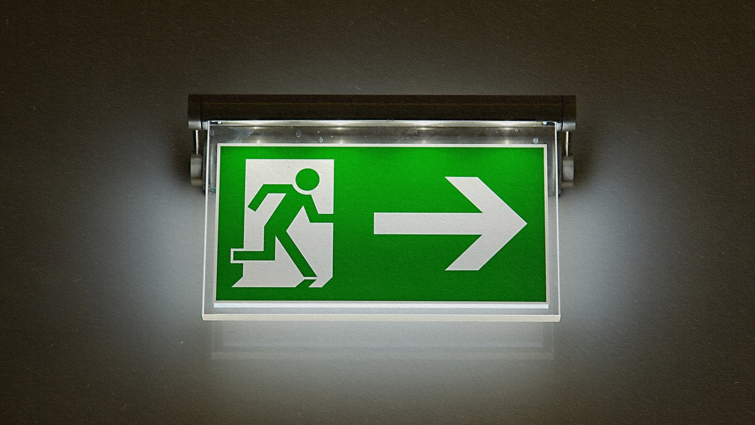 A green exit sign displaying a directional arrow.