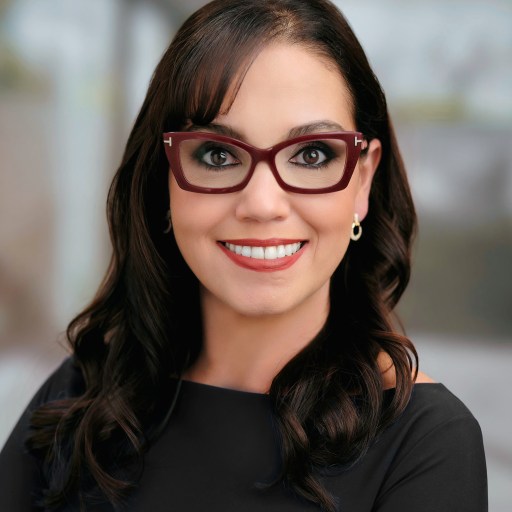 a woman wearing glasses and smiling for the camera.