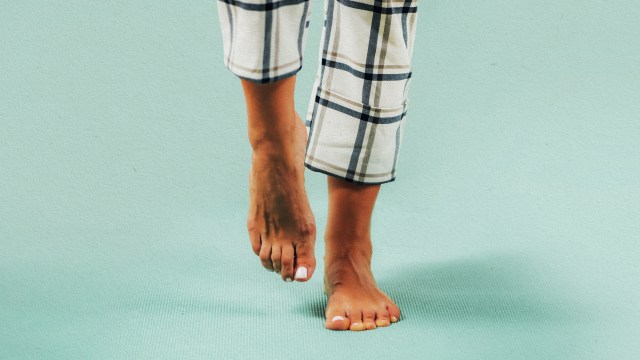 a person standing on a blue floor with their feet up.