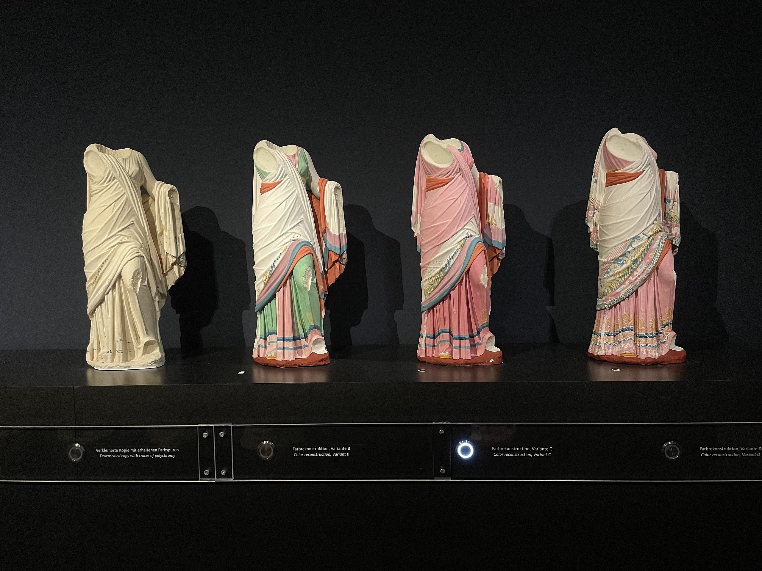 Four Greek statues of a woman in a sari on display.