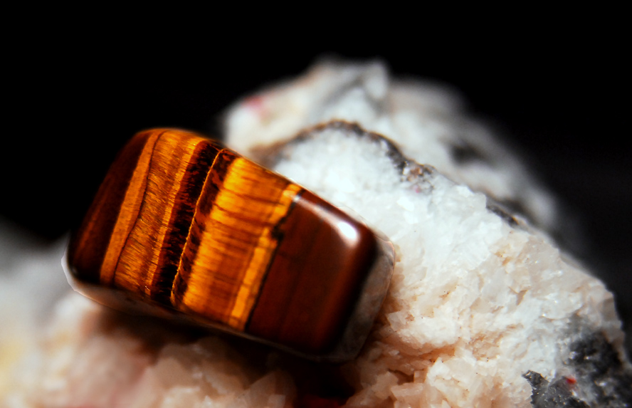 A tiger's eye gemstone on top of a rock.