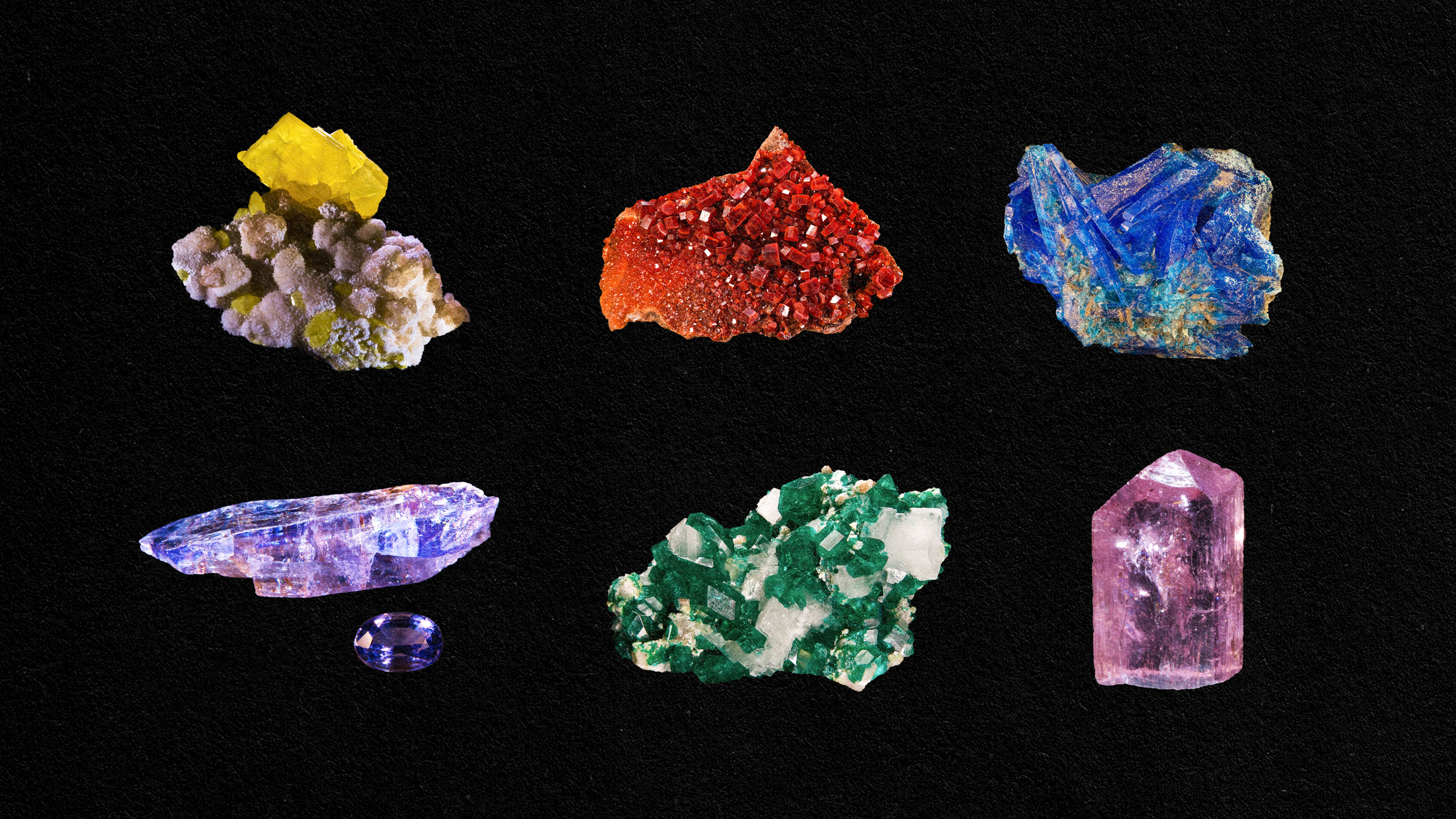 A collection of different colored minerals on a black background.