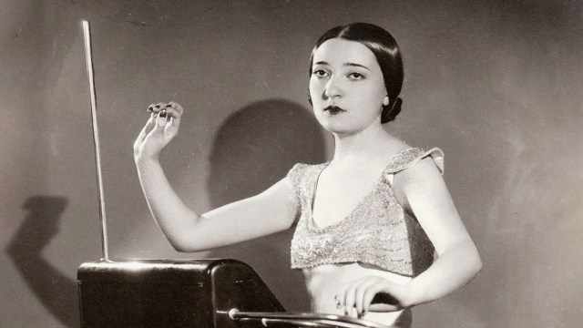 An old photo of a woman holding a theremin.