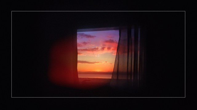 An image of a sunset through a window.