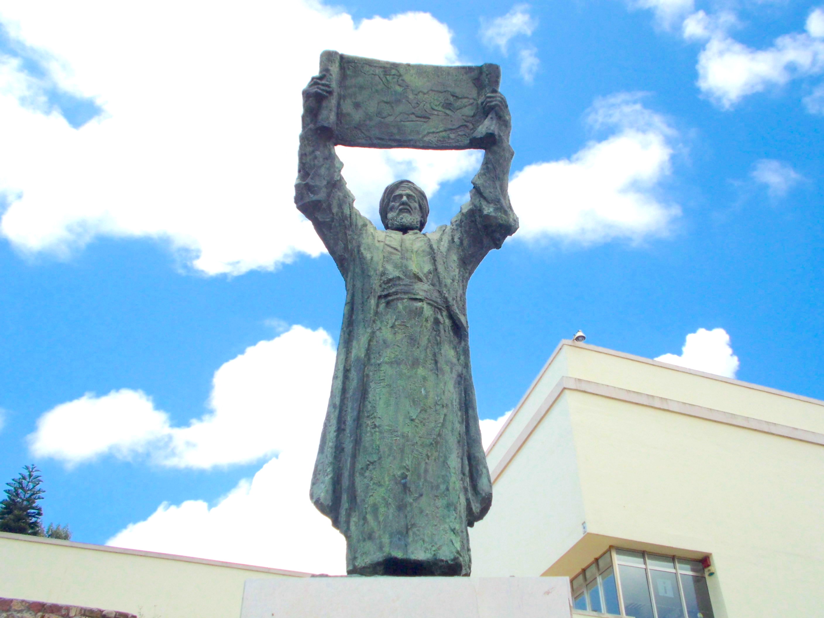 A statue of a man holding up a piece of paper.
