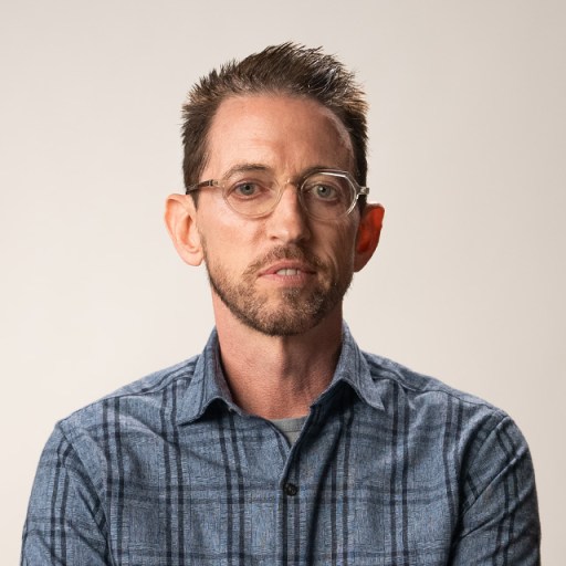 A man wearing glasses and a plaid shirt.