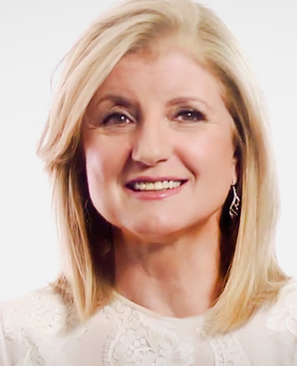 Arianna Huffington smiling in front of a white background.