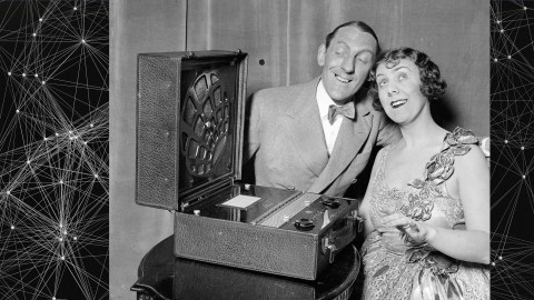 A vintage photograph capturing a couple by a turntable in black and white.