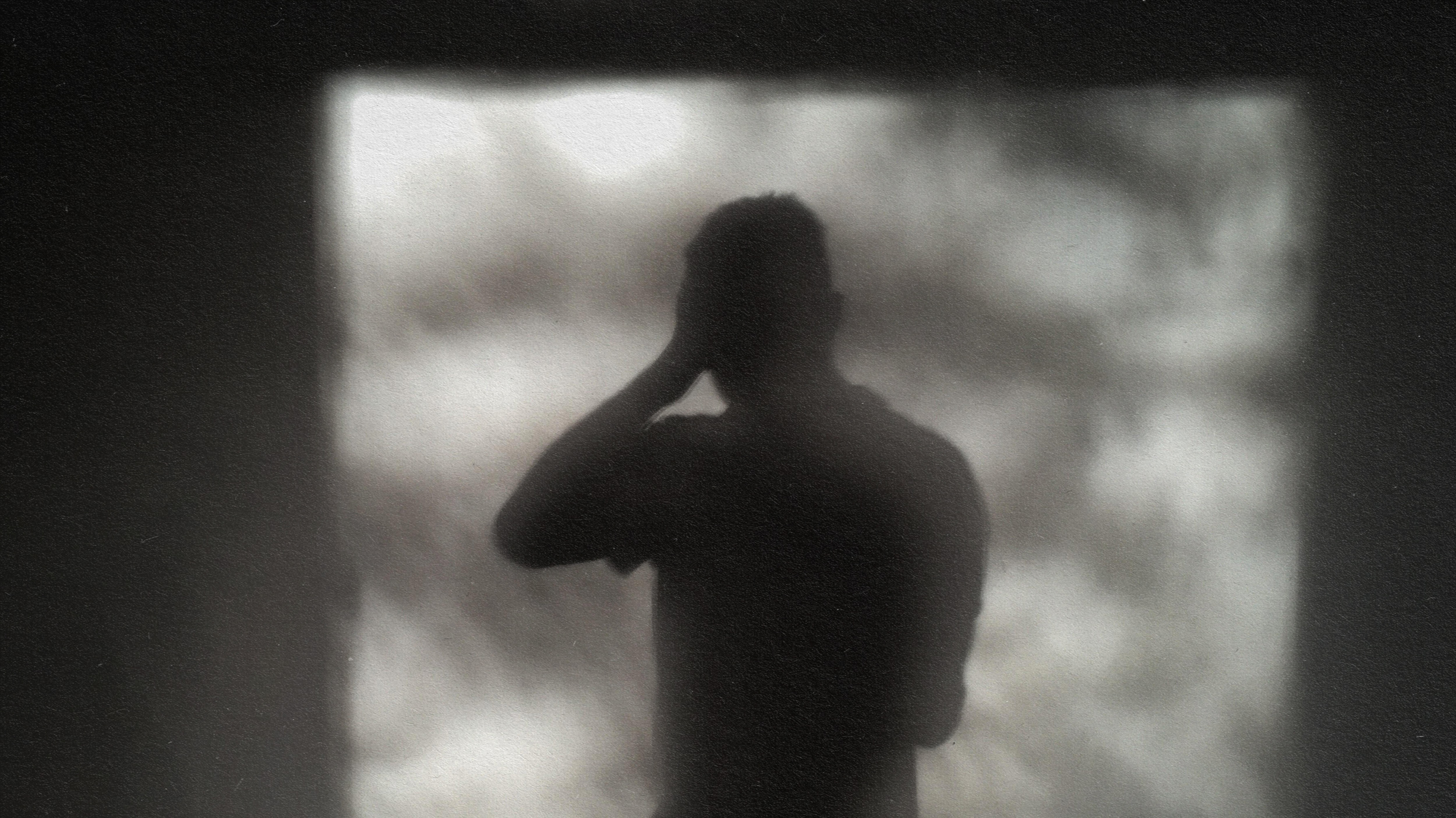 A man's silhouette captured in front of a window.