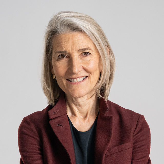 A woman in a burgundy jacket smiling.