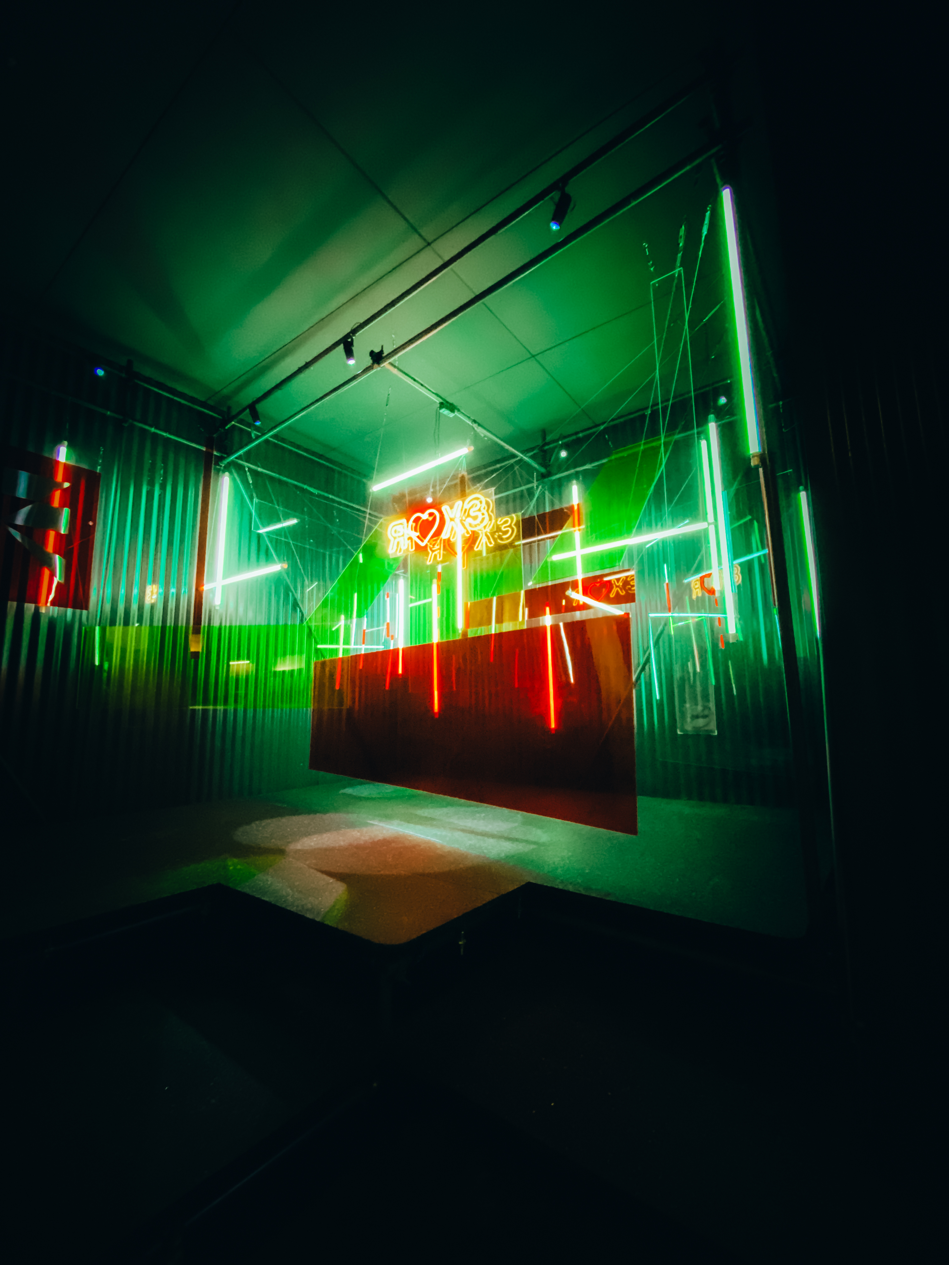 A room with neon lights showcasing the colors green and red.
