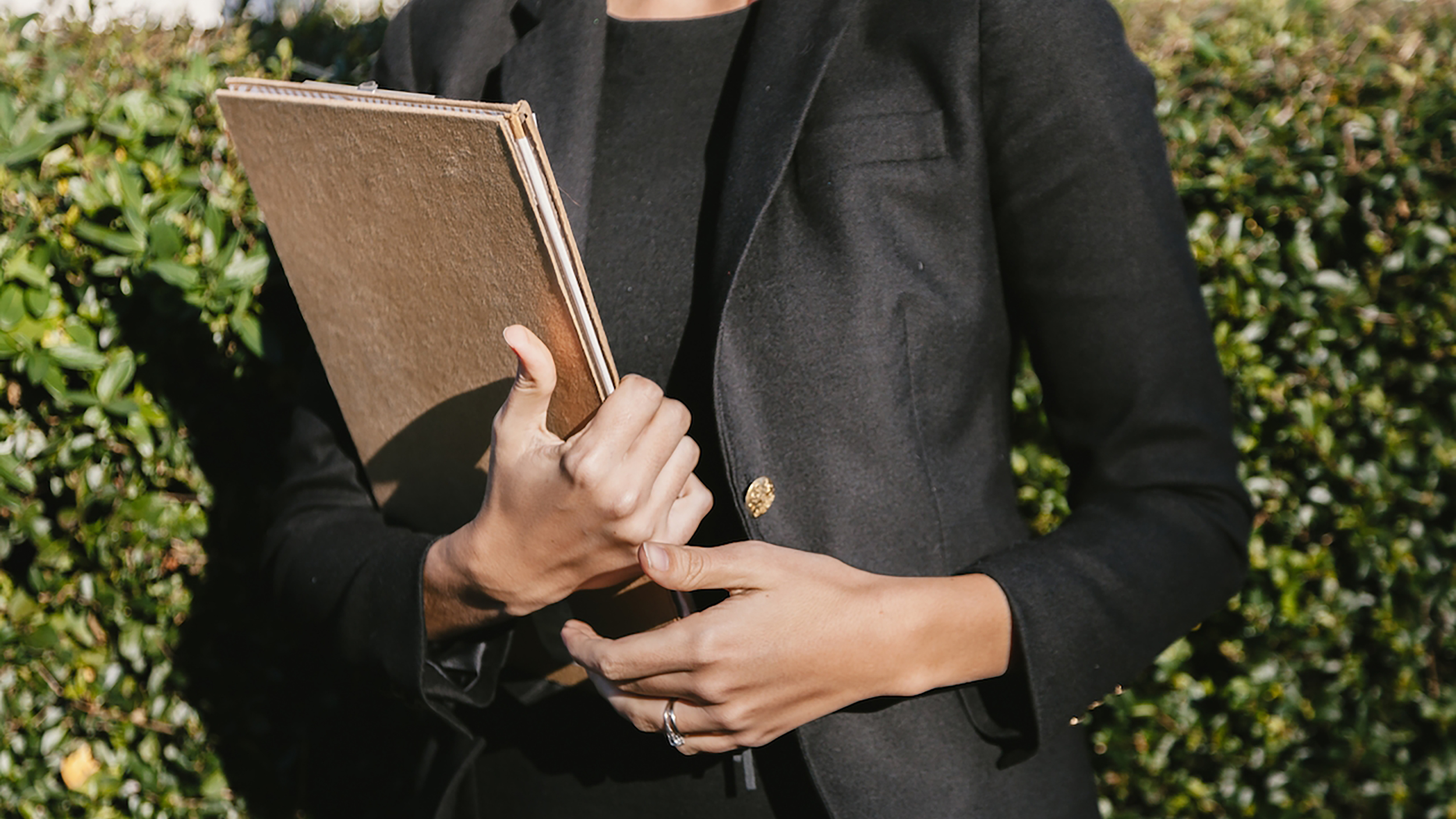 A woman in a business suit exemplifying leadership in the 2020s, confidently holding a folder.