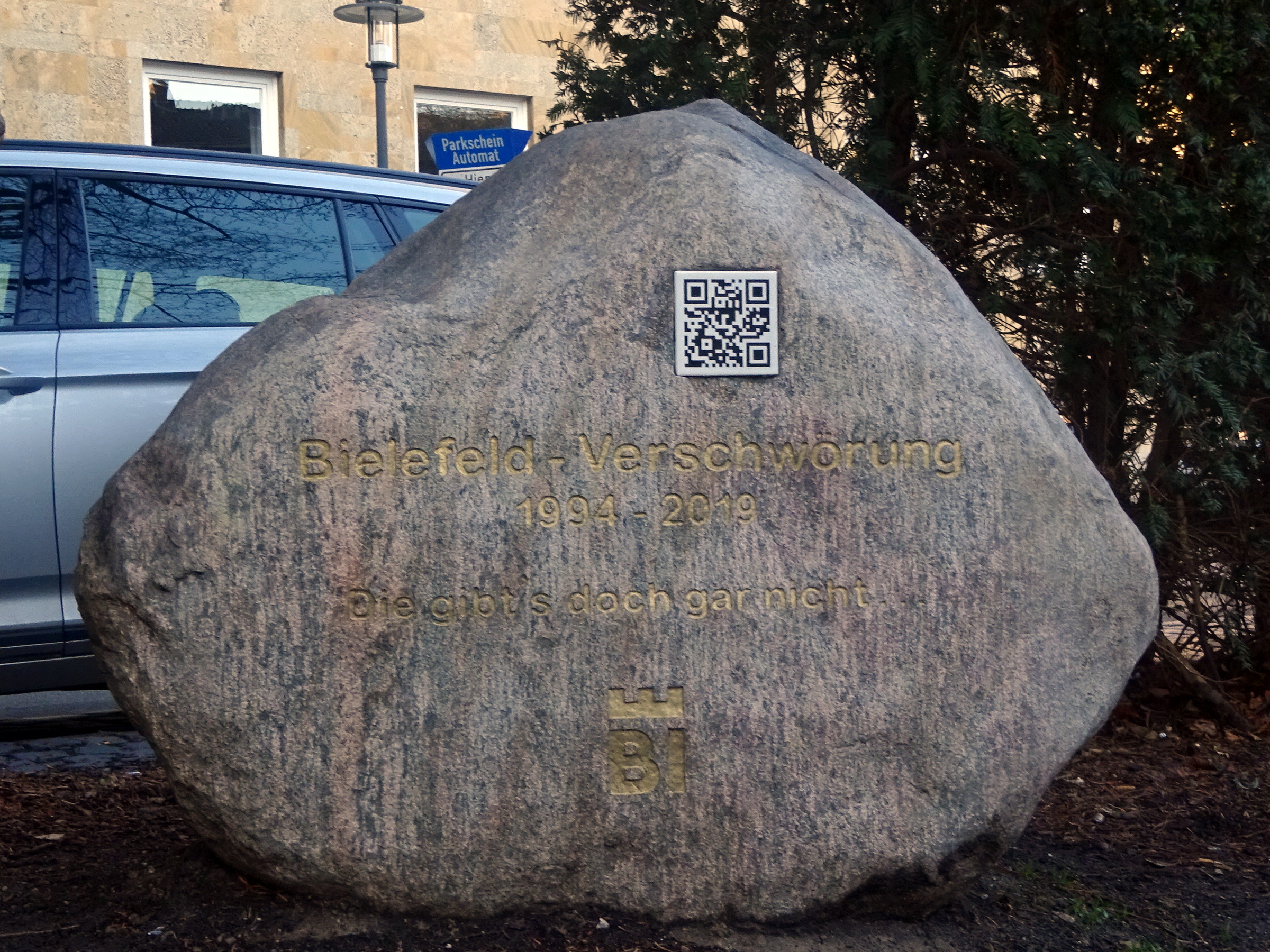 A large rock with a qr code in front of it.