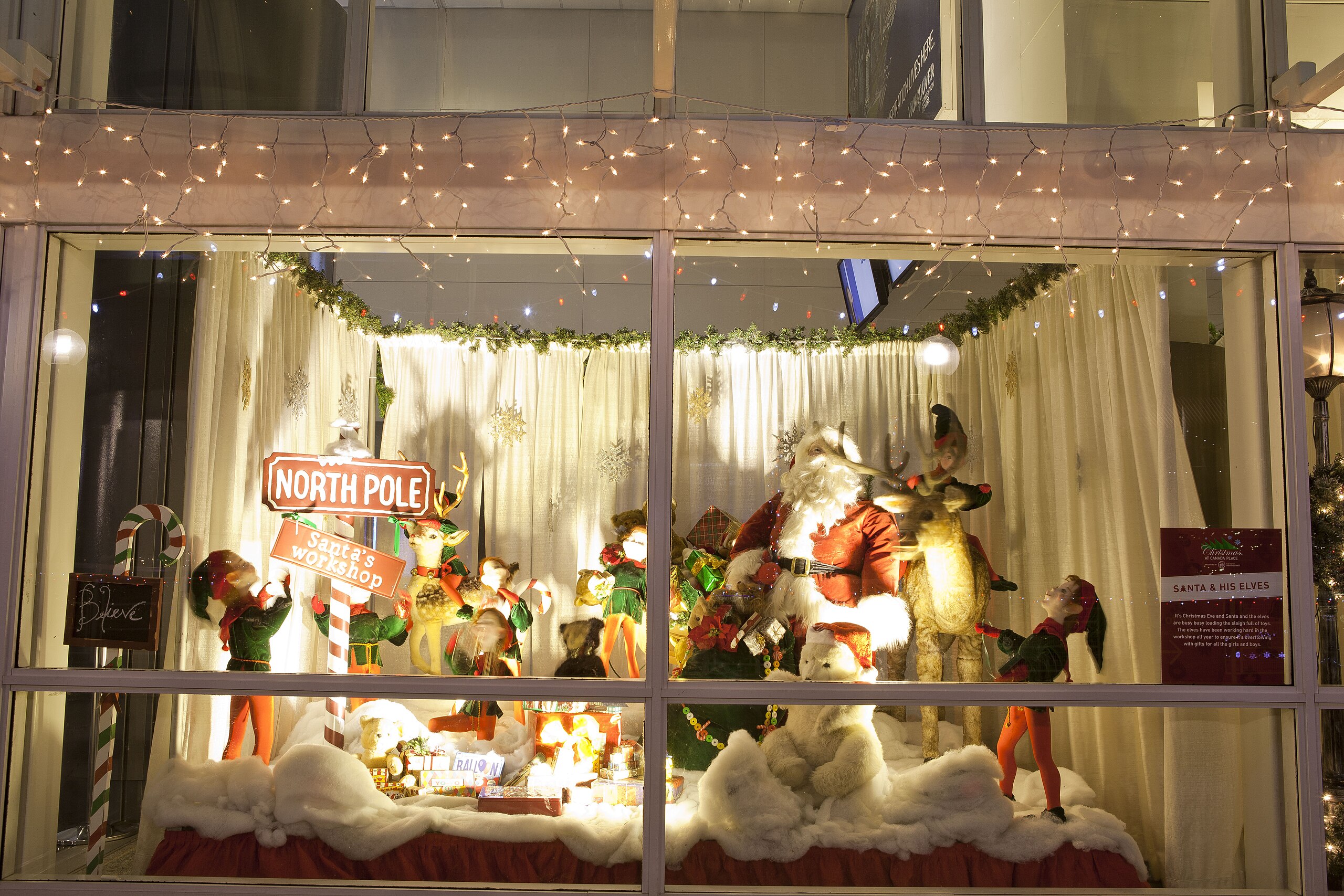 A hazardous display of santa claus figurines in a window.