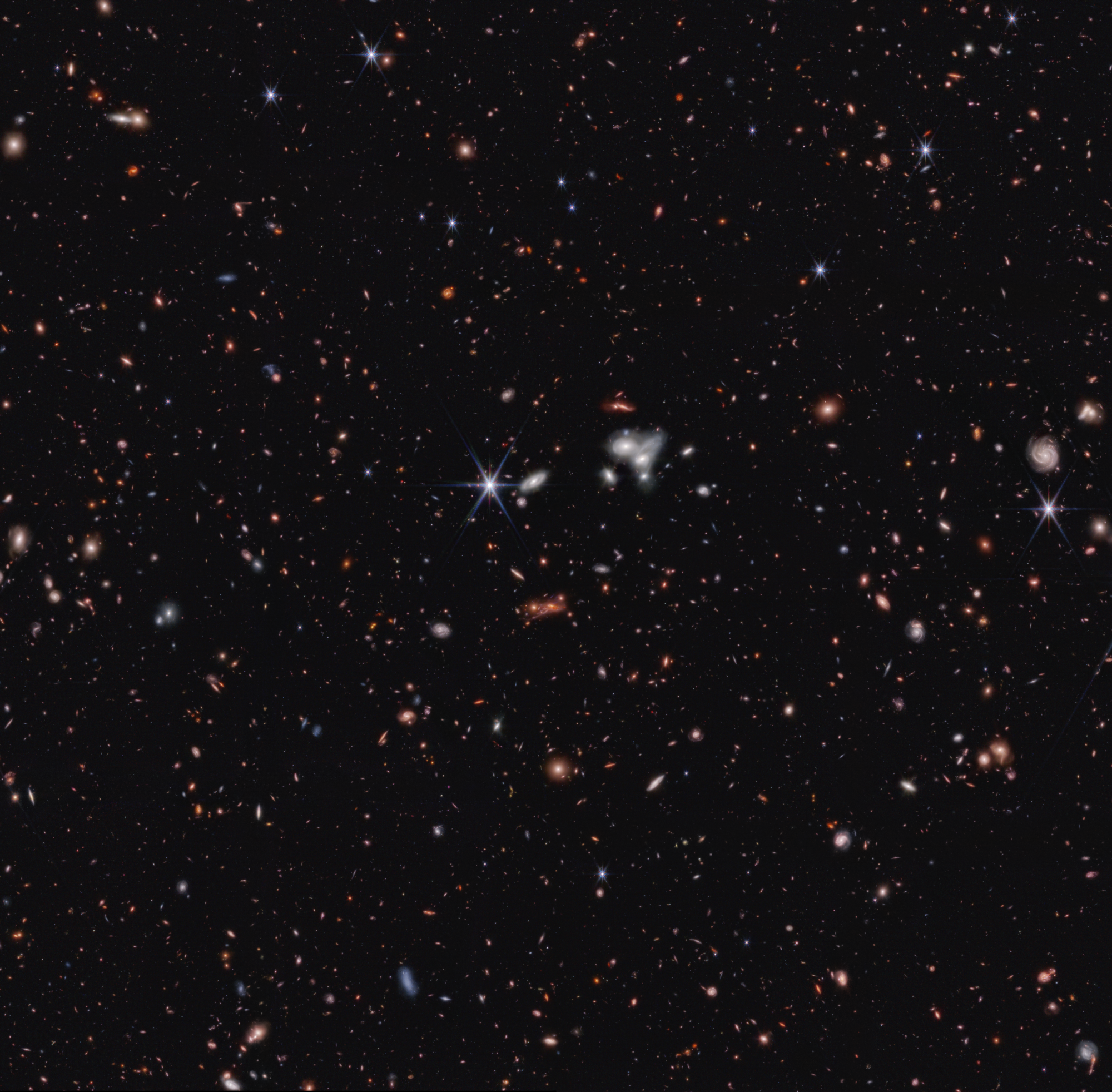 Image of a JWST deep field, showing a lensed cluster of galaxies containing the early black hole CEERS 1019