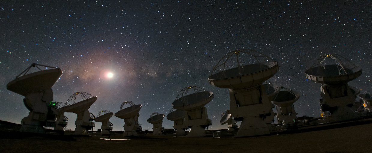 A group of satellite dishes under a starry sky, capturing celestial signals from star birth.