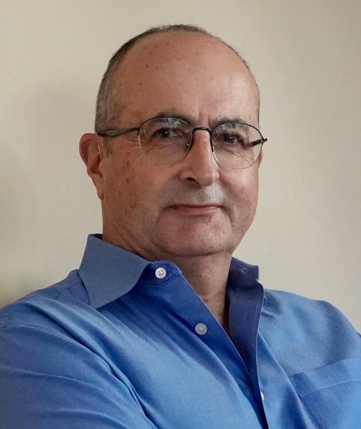 A man wearing glasses and a blue shirt.