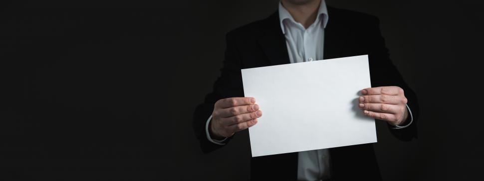 A businessman folding a blank piece of paper.