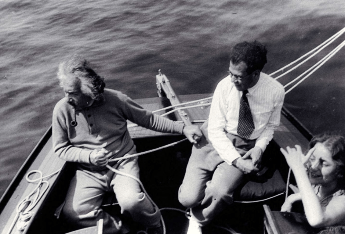 A man holding a rope to another man on a boat.