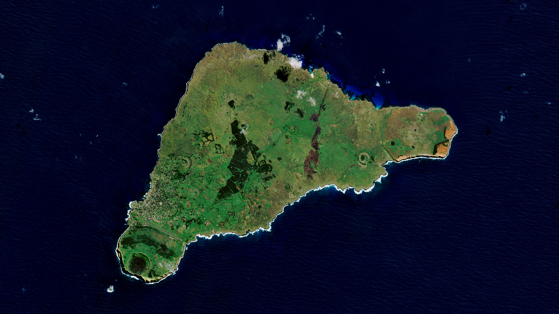 A satellite image of Easter Island, a green island in the ocean.