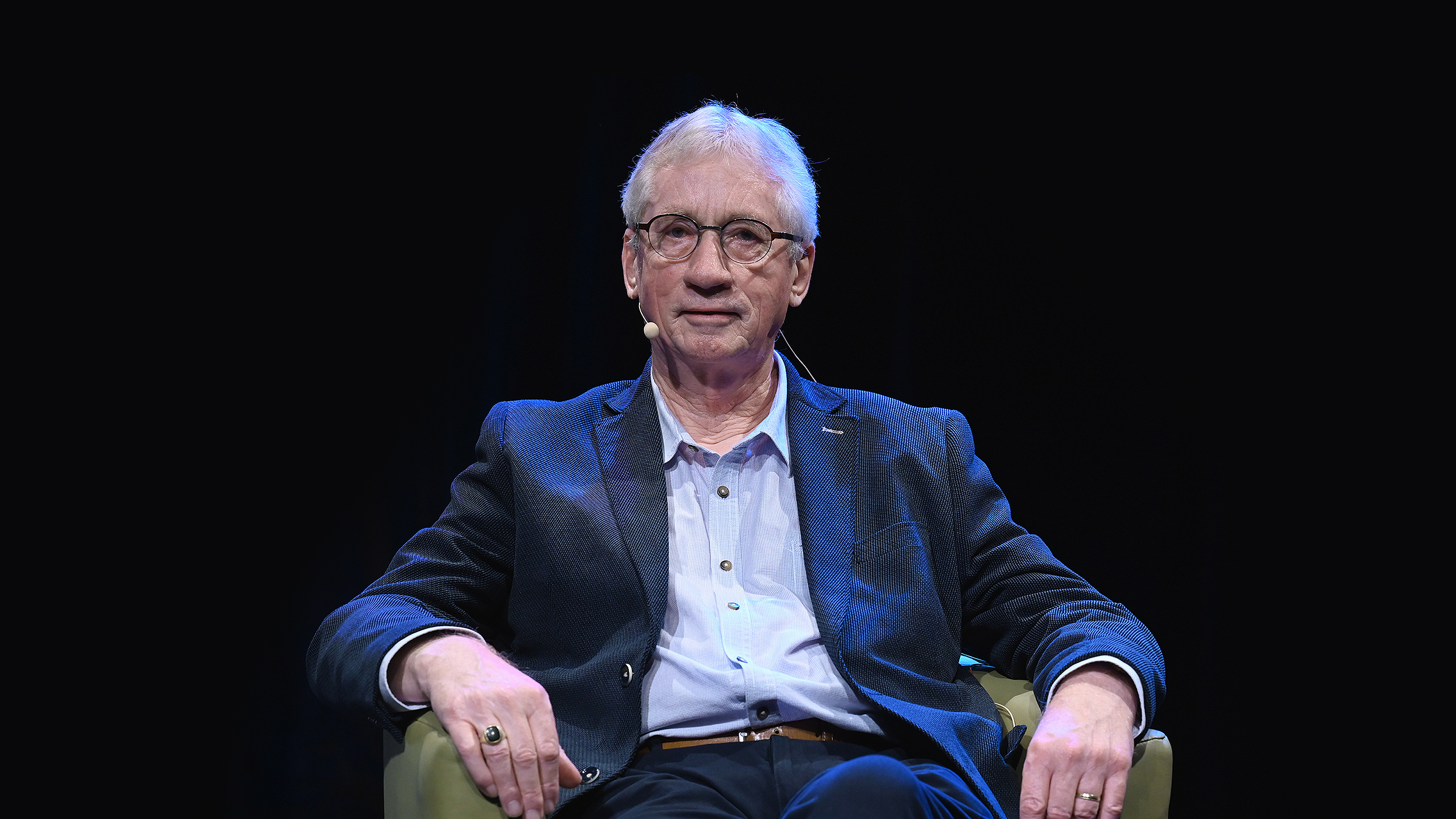 Man sitting on a chair on stage during a Frans de Waal event.