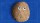 A brown rock with two googly eyes is placed against a blue textured background.