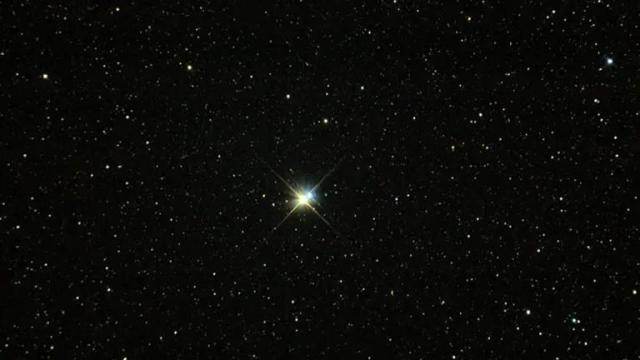 A bright star shining in a dark sky filled with numerous smaller stars. The larger star appears at the center with a noticeable twinkle effect.