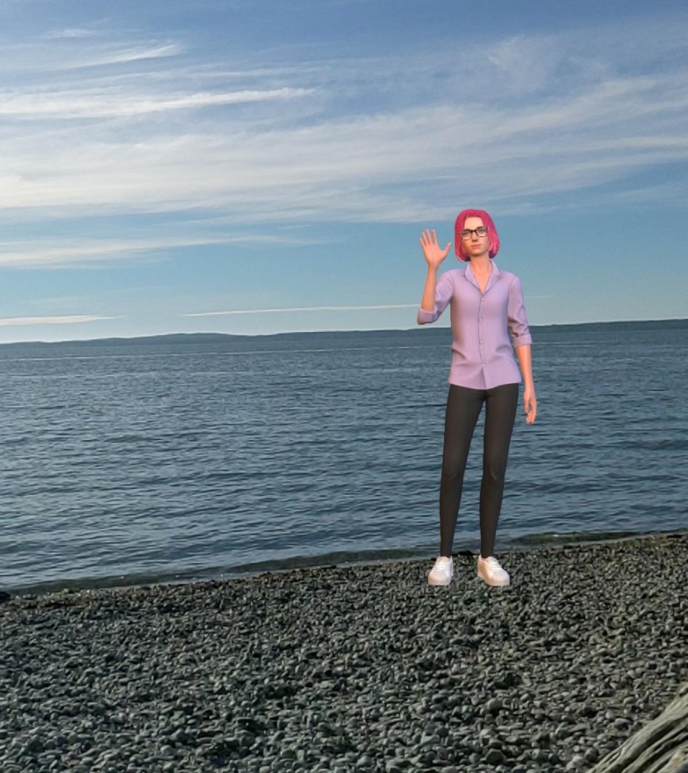 A person with pink hair waves while standing on a rocky shore with a calm sea and cloudy sky in the background.