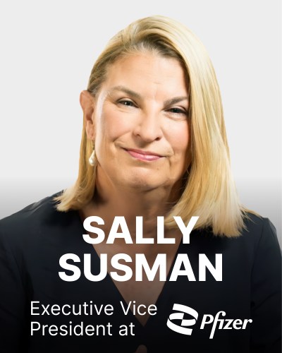 A person with blonde hair is smiling slightly, wearing a dark top. Text reads: "Sally Susman, Executive Vice President at Pfizer" with the Pfizer logo.