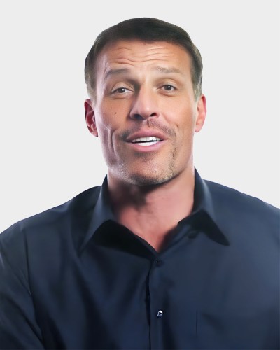 A person in a dark shirt is speaking, shown against a plain white background.