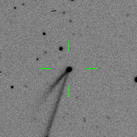 Black and white image of a comet with a visible tail, centered in crosshairs against a speckled background.