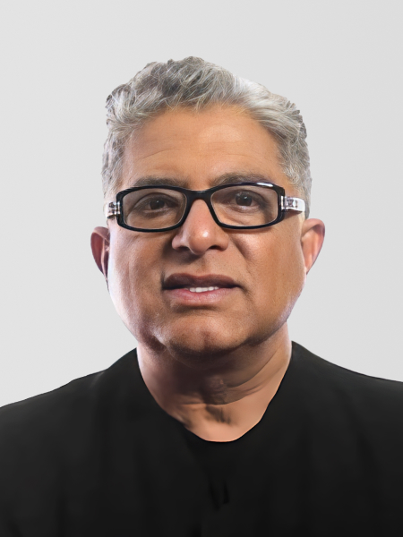 Deepak Chopra wearing glasses and a black shirt, against a plain background.